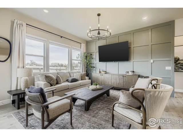 a living room with furniture a flat screen tv and a floor to ceiling window