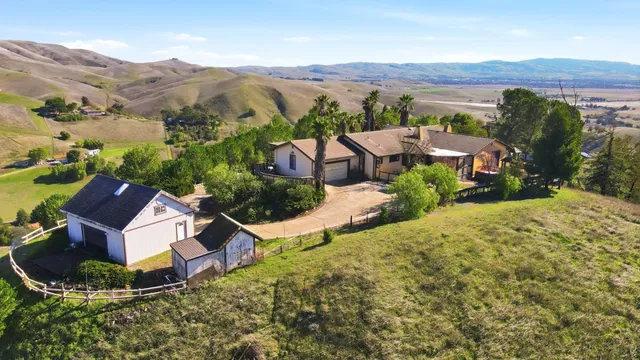 an aerial view of residential houses with outdoor space and trees
