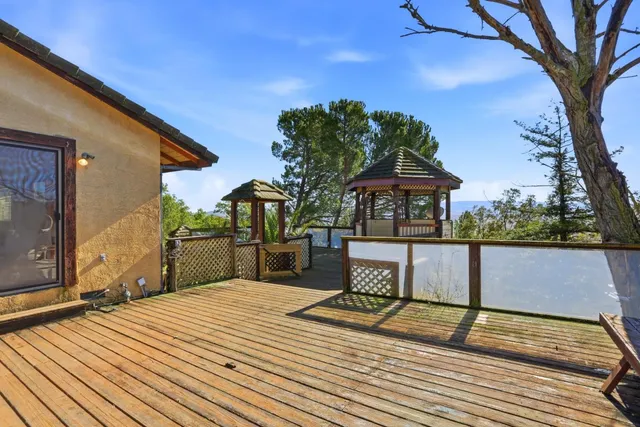 a view of a balcony with wooden floor and a floor to ceiling window