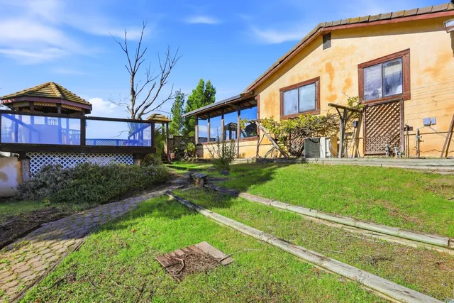 an aerial view of a house with a mountain
