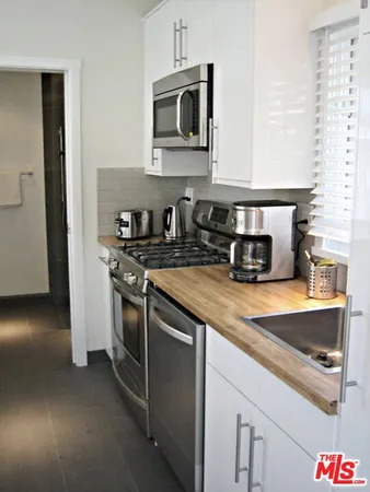 a kitchen with stainless steel appliances granite countertop a sink stove and microwave