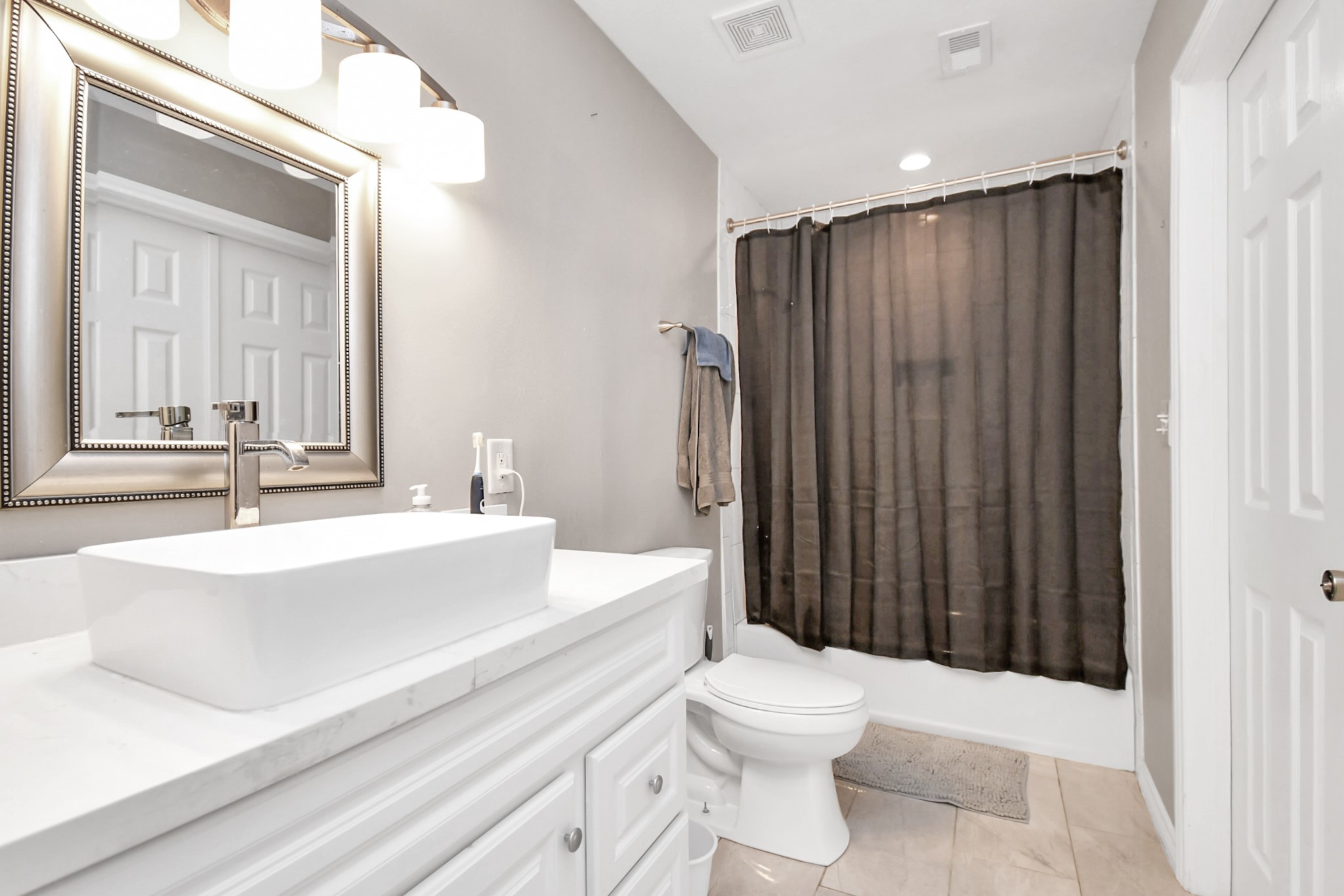 3743 Odin Court Houston, TX 77021 - Photo 28 of 36 This bathroom showcases excellent lighting, a sleek vessel sink configuration, and a pristine shower-tub combo designed for easy utility.
