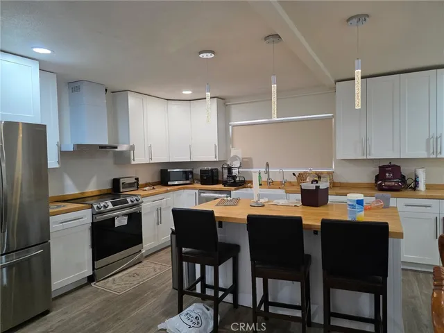 a kitchen that has a lot of cabinets in it with appliances and cabinets