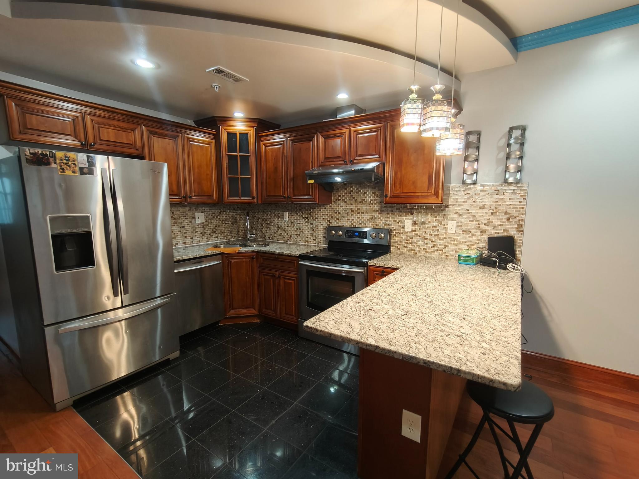 1106 Wallace Street, Unit B Philadelphia, PA 19123 - Photo 2 of 28 a kitchen with stainless steel appliances granite countertop a sink refrigerator and cabinets
