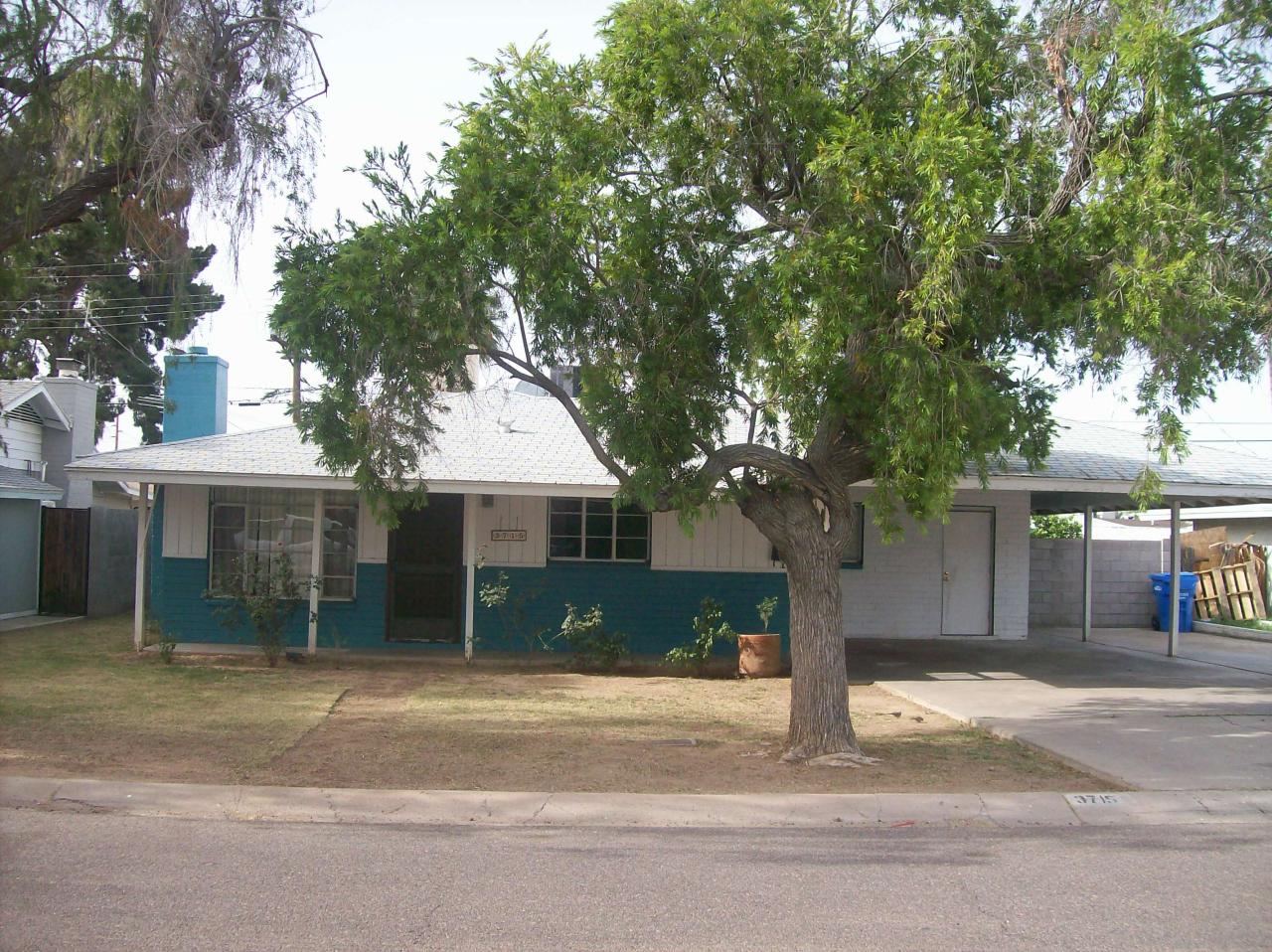 3715 West Lamar Road Phoenix, AZ 85019 - Photo 1 of 9 a house that has a tree in front of it