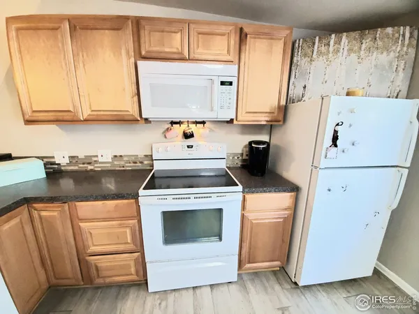 a kitchen with white cabinets and white appliances