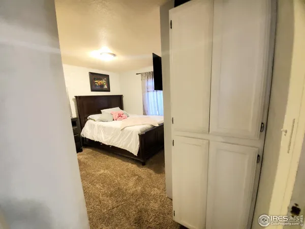 a bedroom with a bed and a painting on the wall