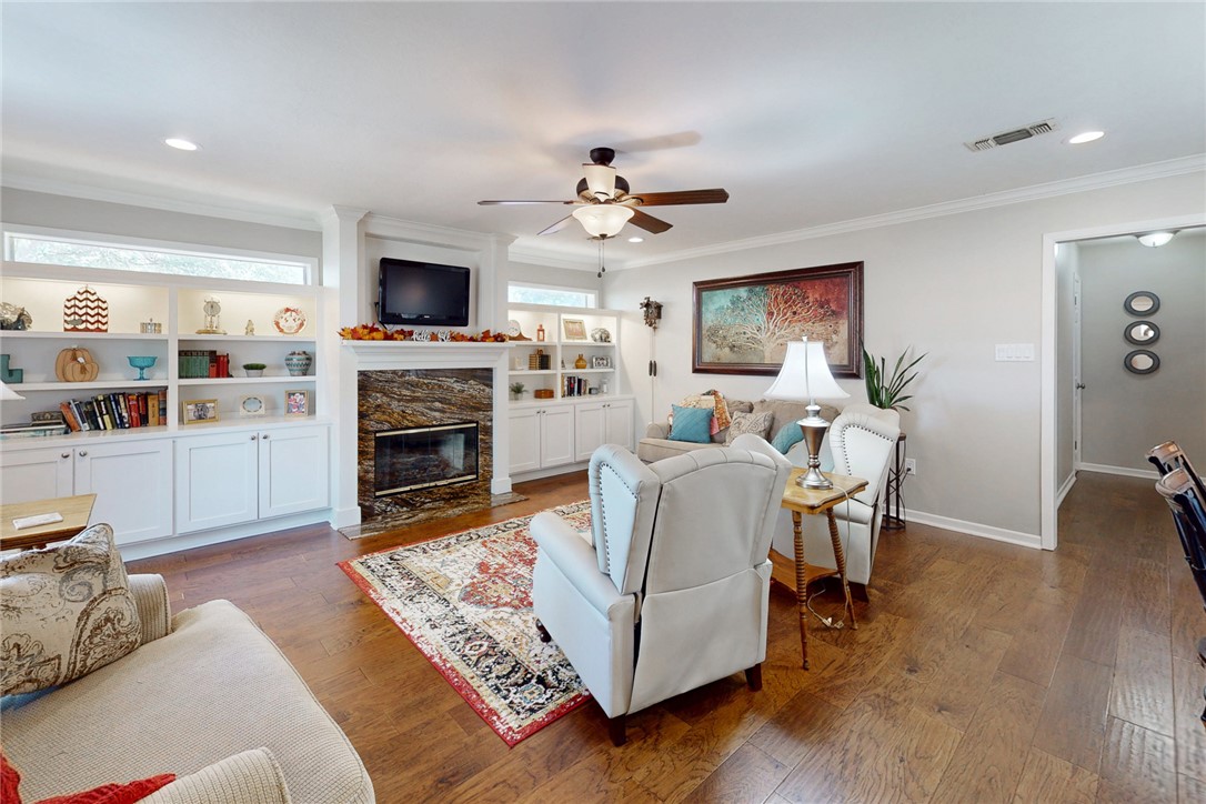 3710 Mancuso Road Bryan, TX 77808 - Photo 6 of 42 Living area featuring dark wood finished floors, crown molding, a fireplace, ceiling fan, and recessed lighting