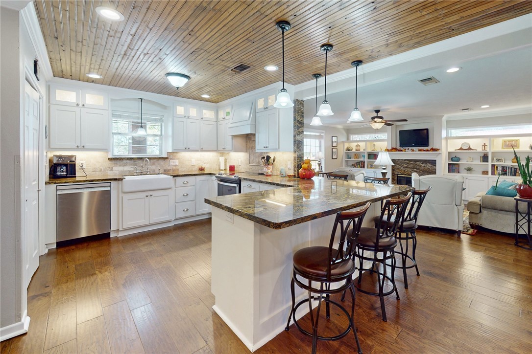3710 Mancuso Road Bryan, TX 77808 - Photo 10 of 42 Kitchen with glass insert cabinets, pendant lighting, dark stone counters, white cabinets, and wood ceiling