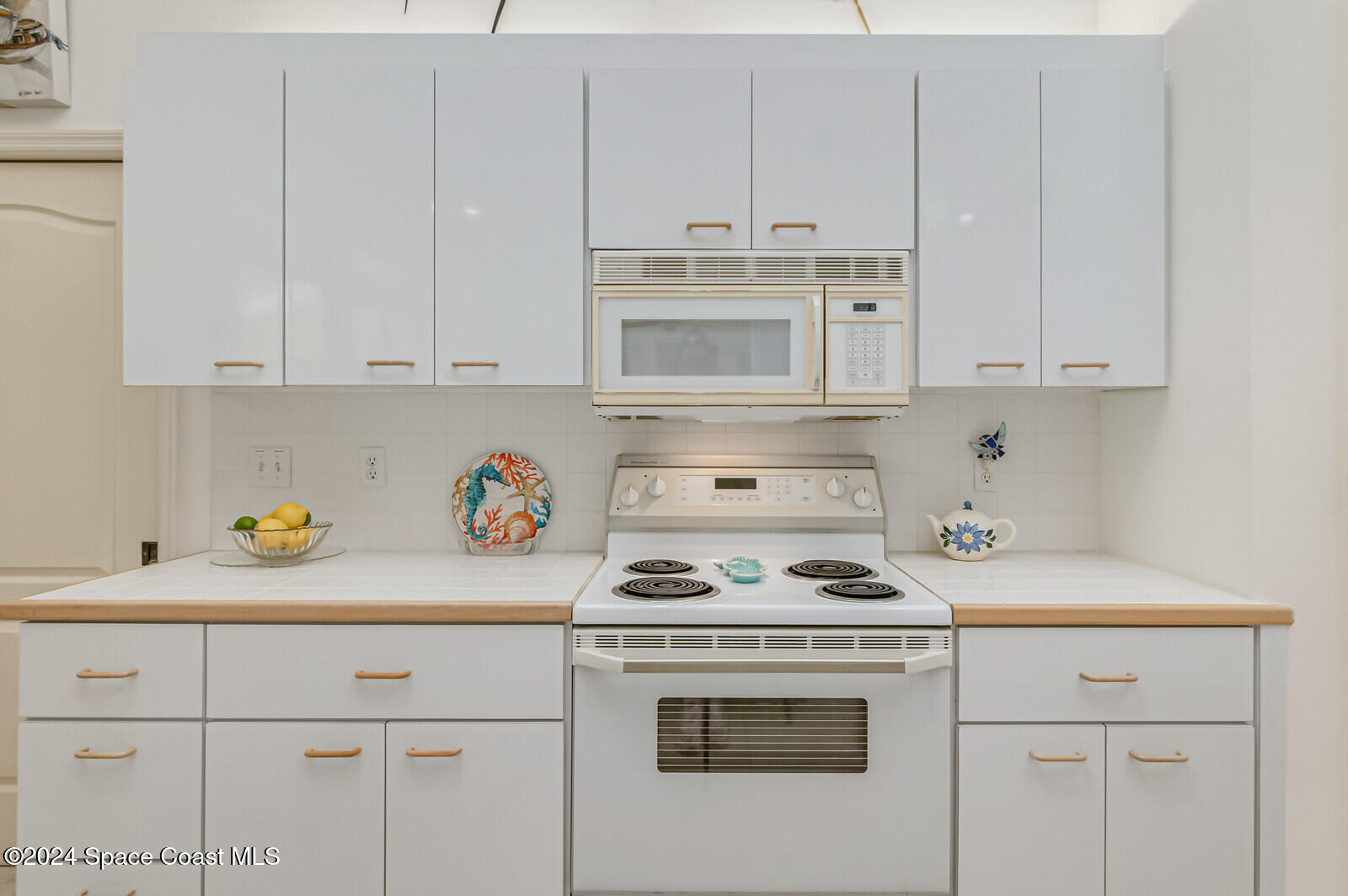 410 Oriole Lane Indialantic, FL 32903 - Photo 21 of 92 a kitchen with white cabinets and white appliances