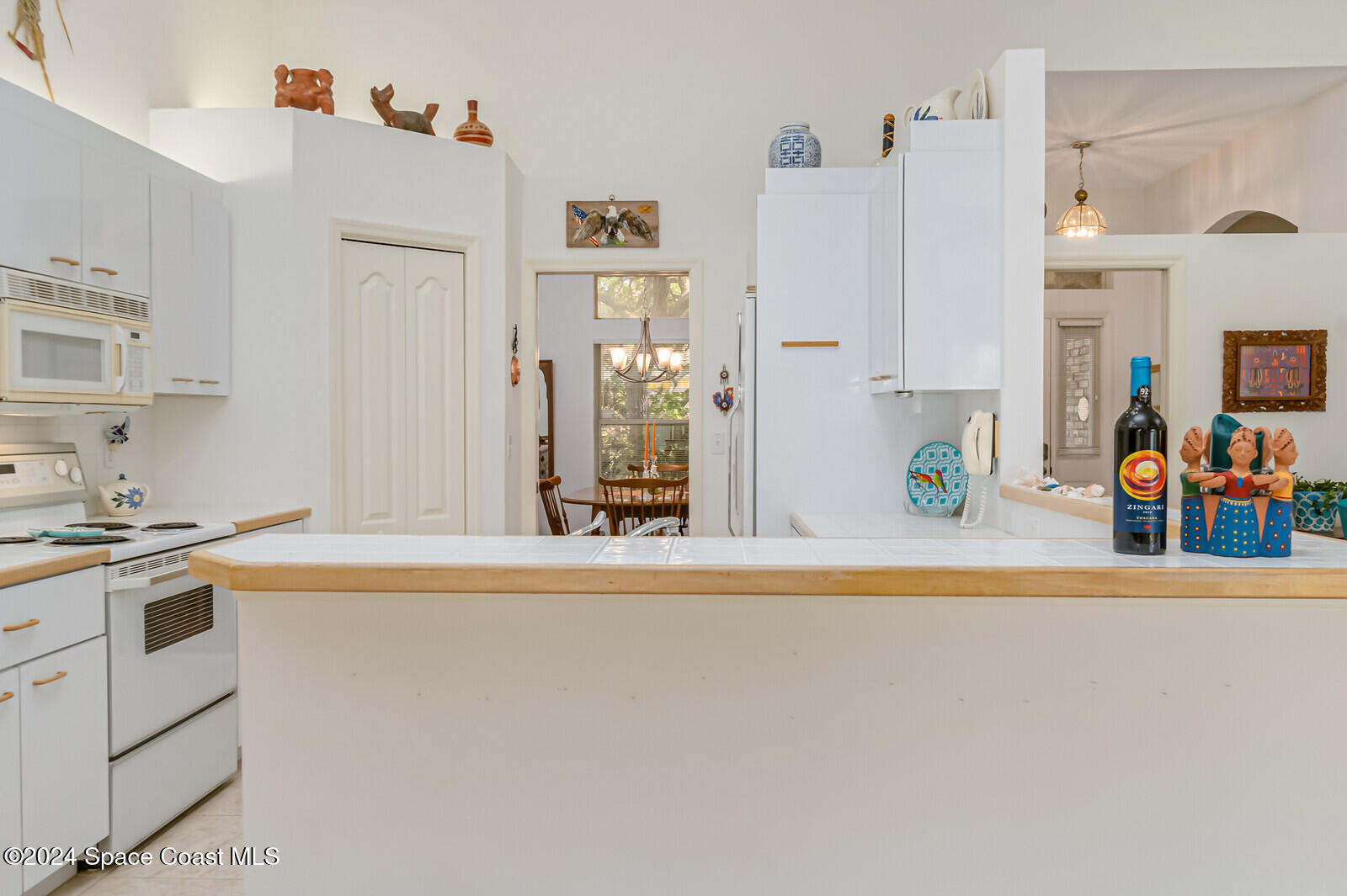 410 Oriole Lane Indialantic, FL 32903 - Photo 23 of 92 a white kitchen with stainless steel appliances a refrigerator and a stove
