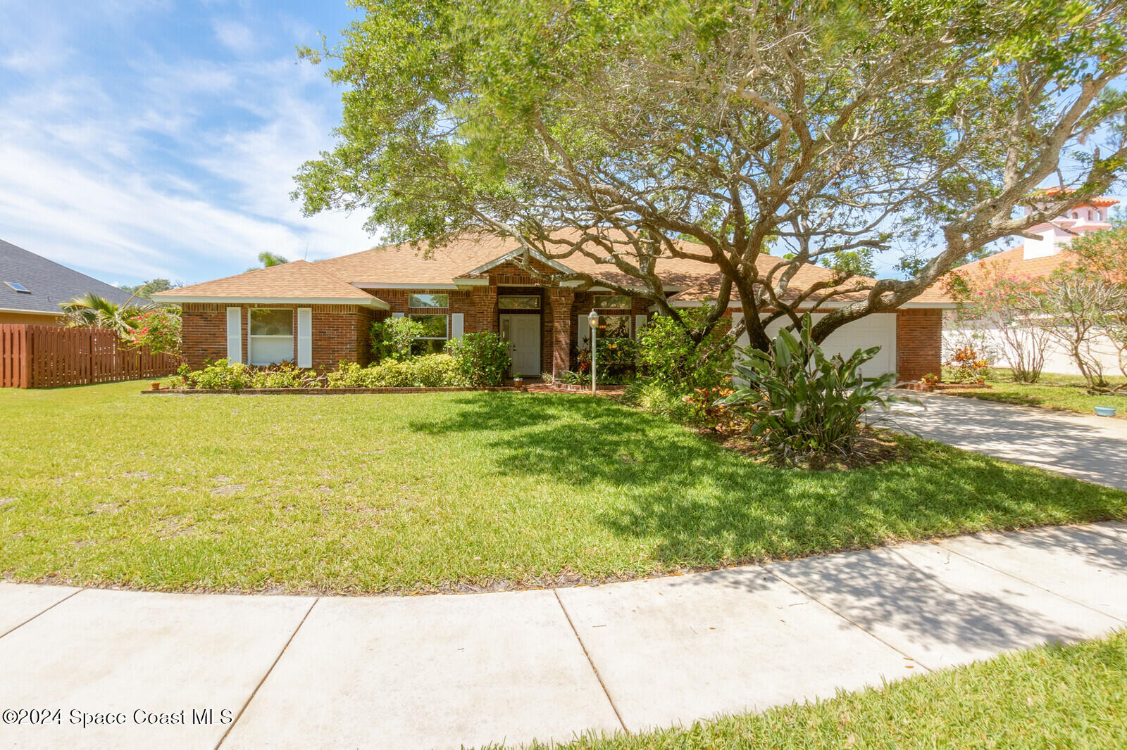 410 Oriole Lane Indialantic, FL 32903 - Photo 3 of 92 a front view of a house with a garden and trees