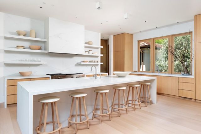 a kitchen with stainless steel appliances granite countertop a stove a sink and white cabinets with wooden floor