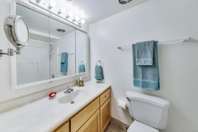 a bathroom with a sink vanity mirror and toilet