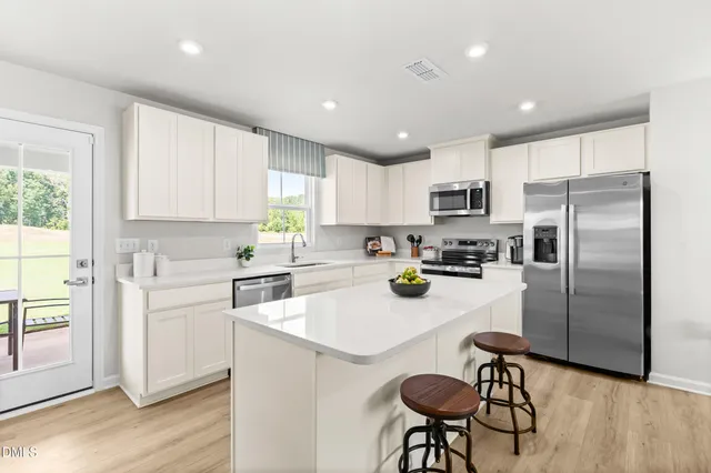 a kitchen with stainless steel appliances granite countertop a sink a stove and a refrigerator
