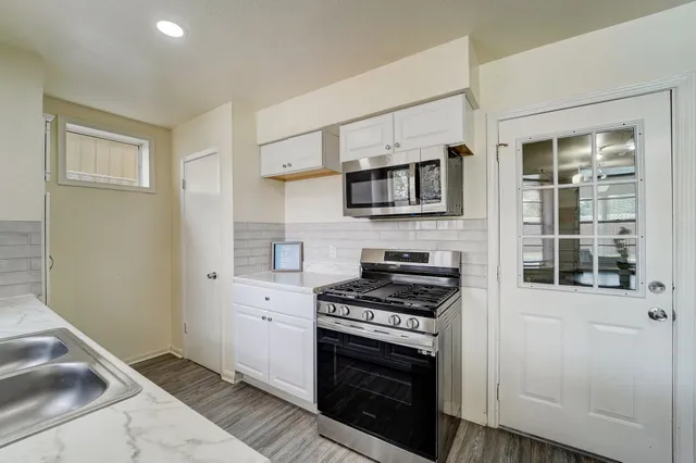 a kitchen with stainless steel appliances a stove a microwave and a sink