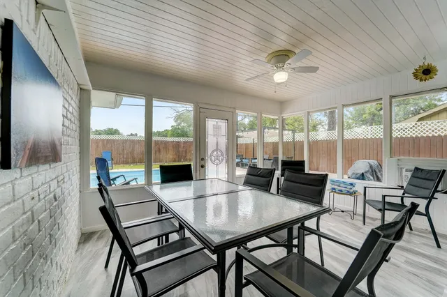 a view of a dining room with furniture large windows and wooden floor