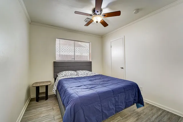 a bedroom with a large bed and a ceiling fan