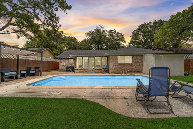 a view of house with swimming pool yard and outdoor seating
