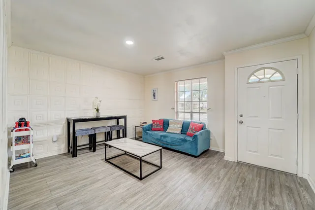 a living room with furniture and a wooden floor