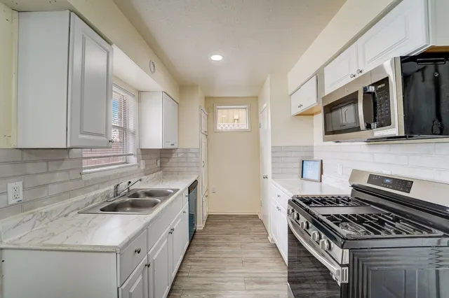 a kitchen with a stove sink and microwave