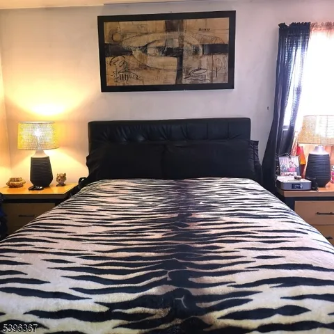 a bedroom with a bed and a painting on the wall