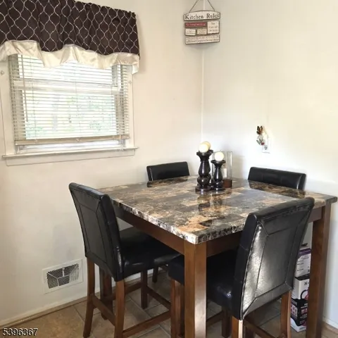 a dining table with chair and a window