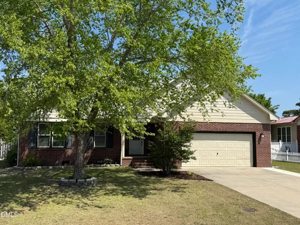 a front view of a house with a yard garage and trees