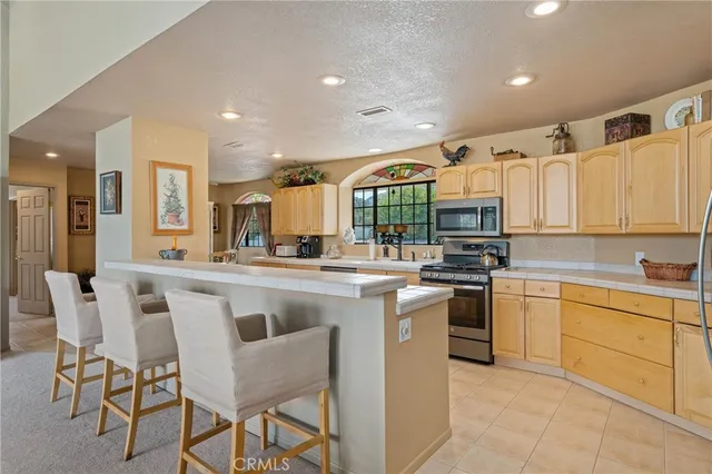 a kitchen with granite countertop a sink stainless steel appliances and cabinets