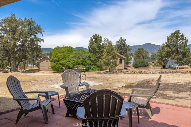 a front view of a house with a yard mountain and mountain view in back