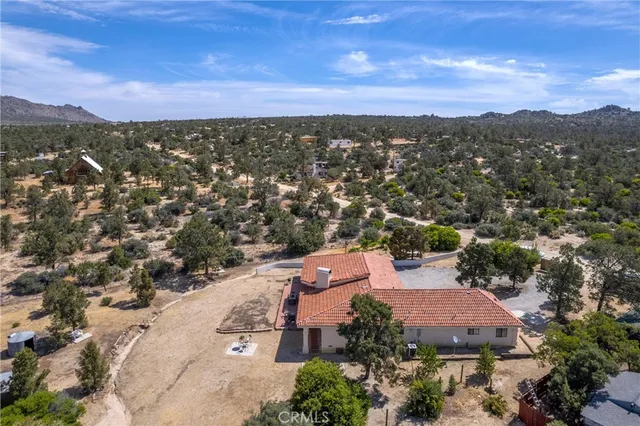 an aerial view of a house with a mountain