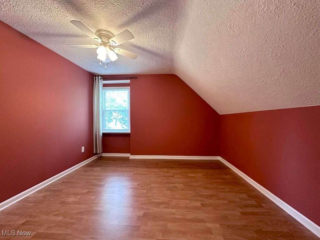 6846 Ottawa Road Cleveland, OH 44105 - Photo 43 of 50 Bonus room featuring baseboards, lofted ceiling, wood finished floors, and a ceiling fan