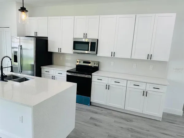 a kitchen with white cabinets and stainless steel appliances