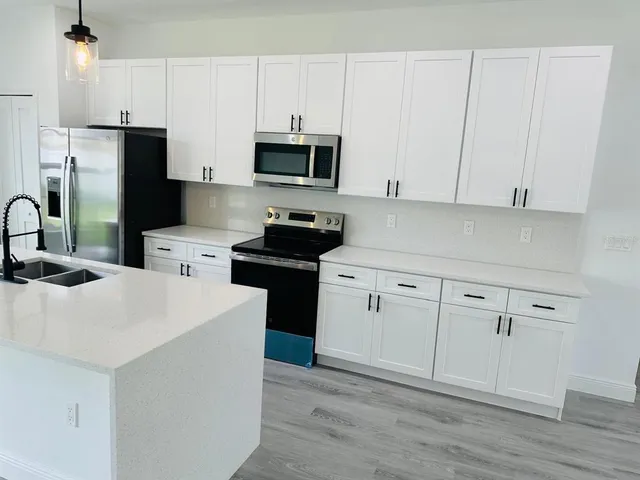 a kitchen with white cabinets and stainless steel appliances