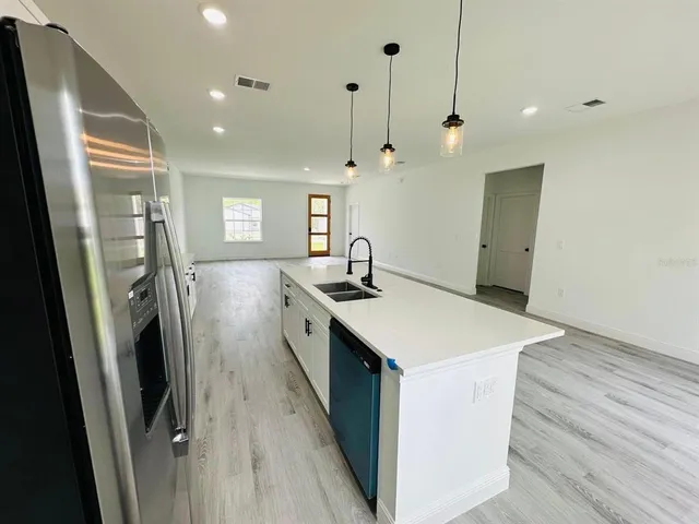 a kitchen with stainless steel appliances a sink stove and refrigerator