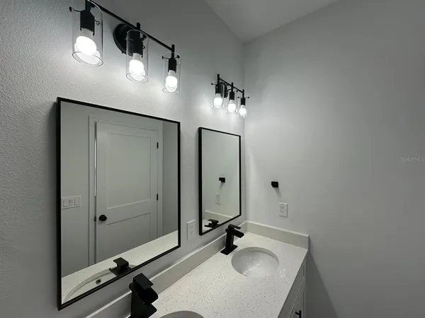 a bathroom with a sink double vanity and a mirror