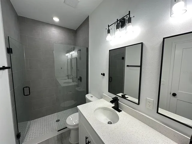 a bathroom with a sink a toilet and shower