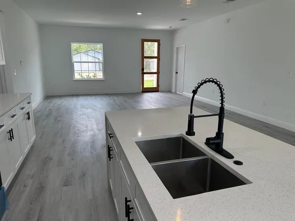 a kitchen with granite countertop a sink and wooden floor