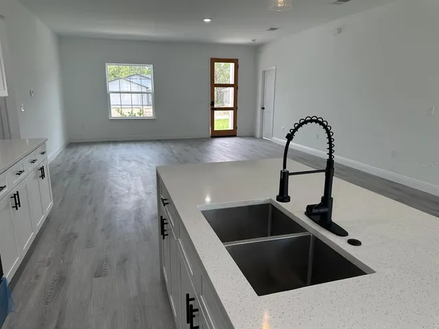 a kitchen with granite countertop a sink and wooden floor