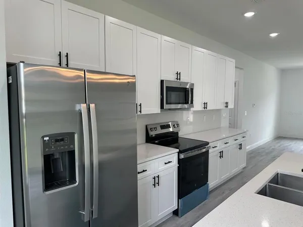 a kitchen with stainless steel appliances a refrigerator sink and microwave