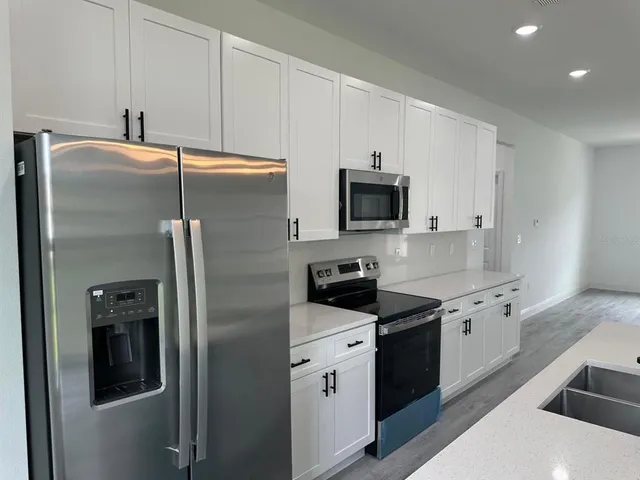 a kitchen with stainless steel appliances a refrigerator sink and microwave