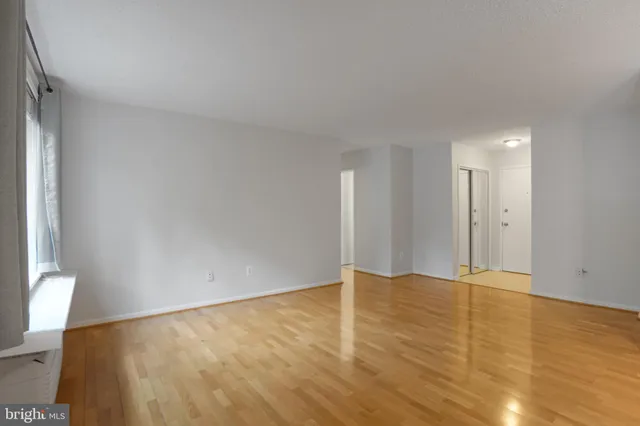 a view of an empty room with wooden floor