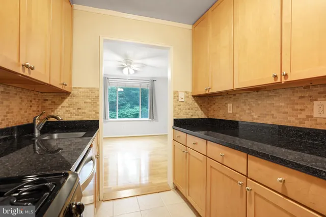 a kitchen with granite countertop sink and cabinets