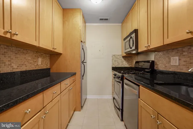 a kitchen with stainless steel appliances granite countertop a sink and a stove