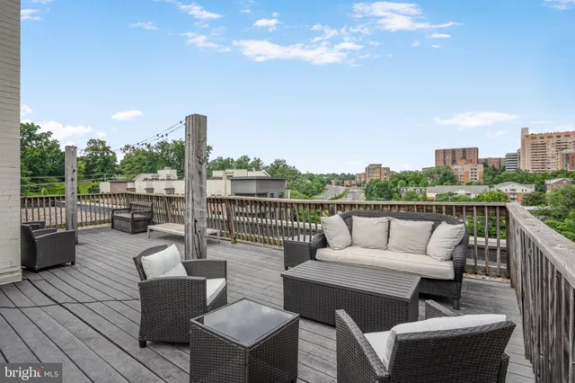 a roof deck with couches and wooden floor
