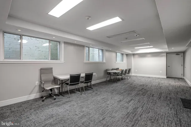a view of a livingroom with lounge chair and windows
