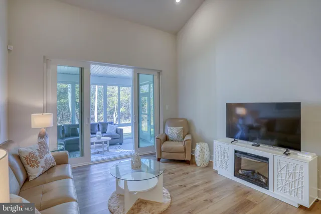 a living room with furniture a flat screen tv and kitchen view