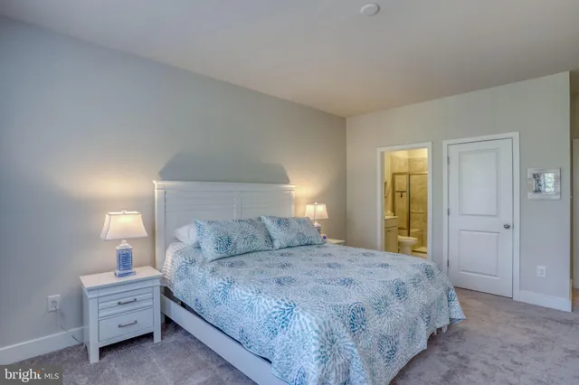 a bedroom with a bed and a lamp on dresser