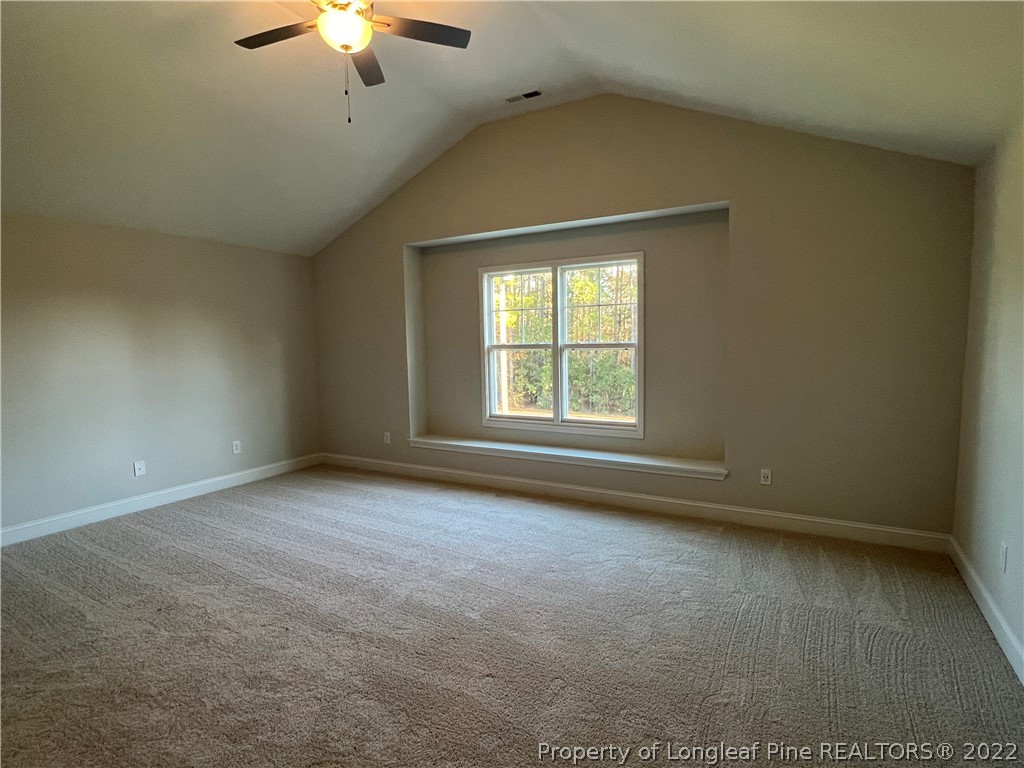 7850 Rufus Johnson Road Fayetteville, NC 28306 - Photo 7 of 11 an empty room with a chandelier fan and windows