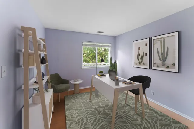 a view of a workspace with furniture and a window